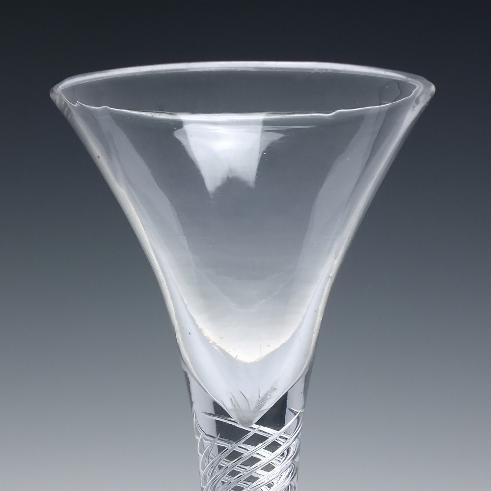 An 18th-century Georgian clear lead glass wine glass featuring a flared bell bowl, an air twist stem with a central knop, and a wide domed foot. View IV