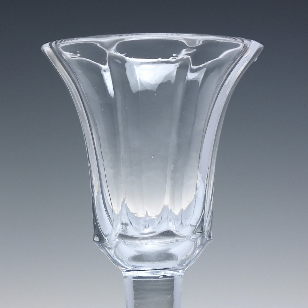 An 18th-century clear lead glass wine goblet featuring an inverted petal moulded bowl, a tall plain stem, and a circular foot. View III
