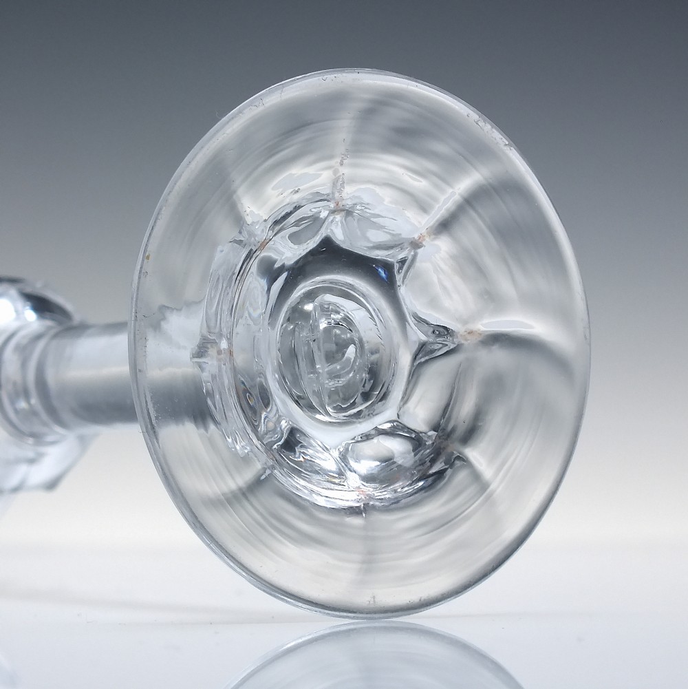 An 18th-century clear lead glass wine goblet featuring an inverted petal moulded bowl, a tall plain stem, and a circular foot. View VIII