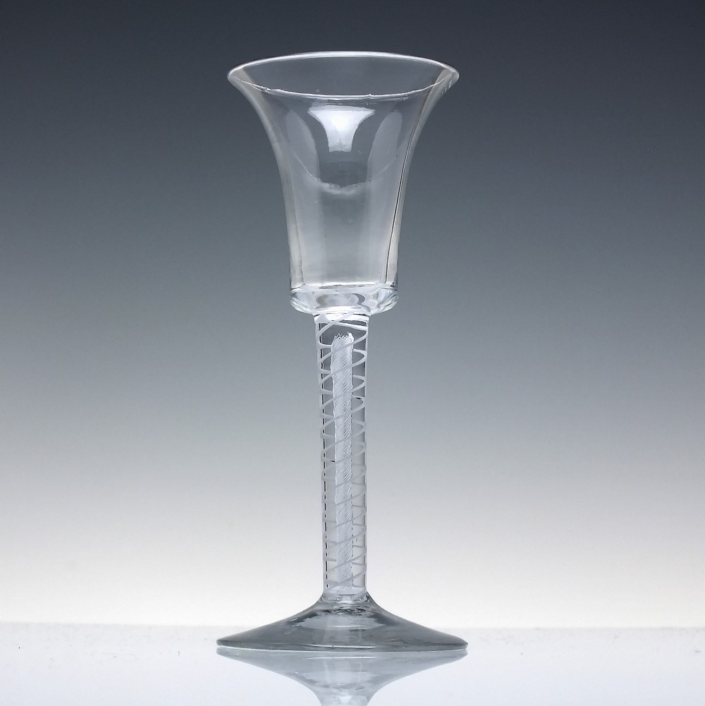An eighteenth-century clear lead glass wine glass featuring a flared bucket bowl and a mixed twist stem on a conical foot. View II