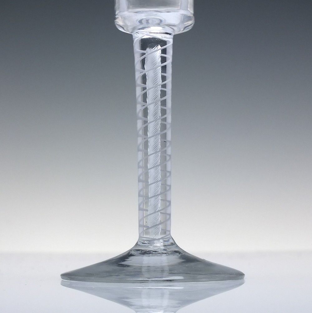 An eighteenth-century clear lead glass wine glass featuring a flared bucket bowl and a mixed twist stem on a conical foot. View III