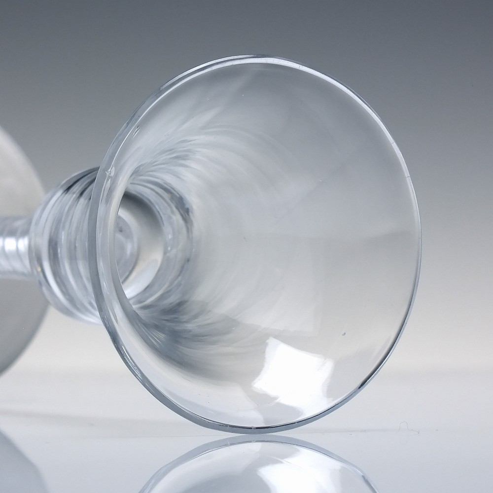An eighteenth-century clear lead glass wine glass featuring a flared bucket bowl and a mixed twist stem on a conical foot. View V