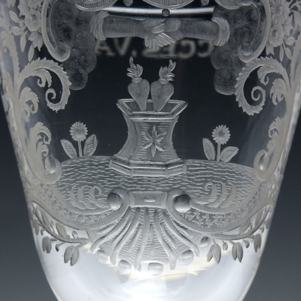 An 18th-century clear lead glass wine goblet featuring detailed wheel-engraved marriage motifs on the bowl and a knopped light baluster stem. View IV