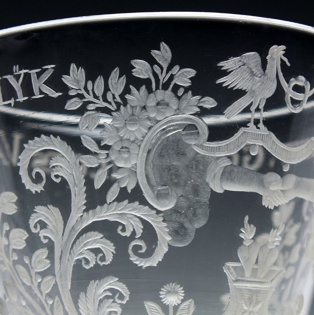 An 18th-century clear lead glass wine goblet featuring detailed wheel-engraved marriage motifs on the bowl and a knopped light baluster stem. View VI