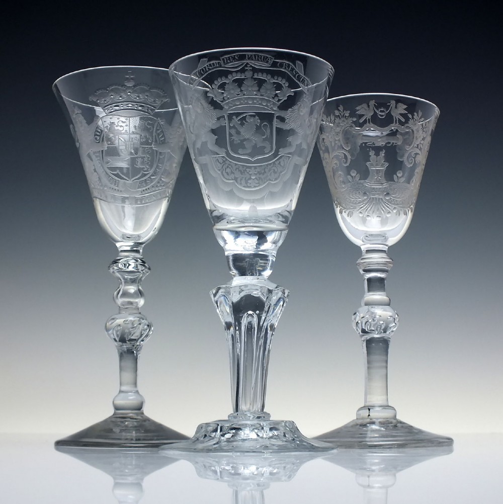 An 18th-century clear glass wine goblet with a wheel-engraved heraldic coat of arms on the bowl, a moulded pedestal stem, and a flat circular foot. View II