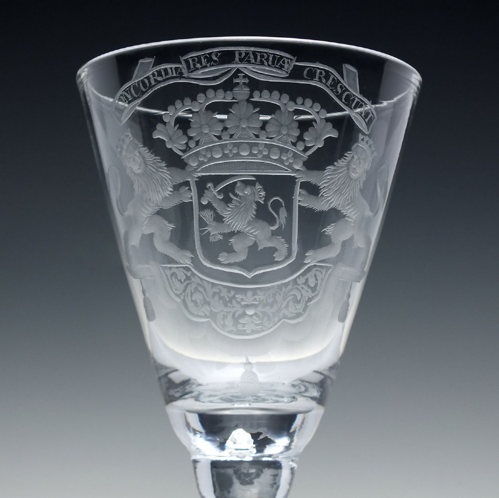 An 18th-century clear glass wine goblet with a wheel-engraved heraldic coat of arms on the bowl, a moulded pedestal stem, and a flat circular foot. View III