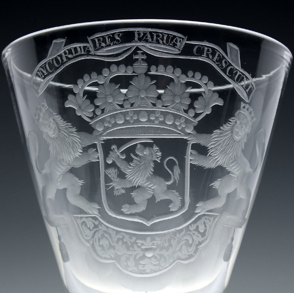 An 18th-century clear glass wine goblet with a wheel-engraved heraldic coat of arms on the bowl, a moulded pedestal stem, and a flat circular foot. View IV