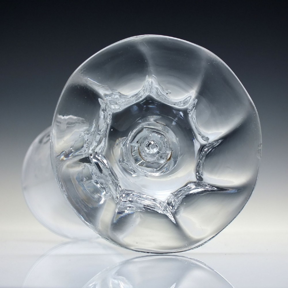 An 18th-century clear glass wine goblet with a wheel-engraved heraldic coat of arms on the bowl, a moulded pedestal stem, and a flat circular foot. View IX