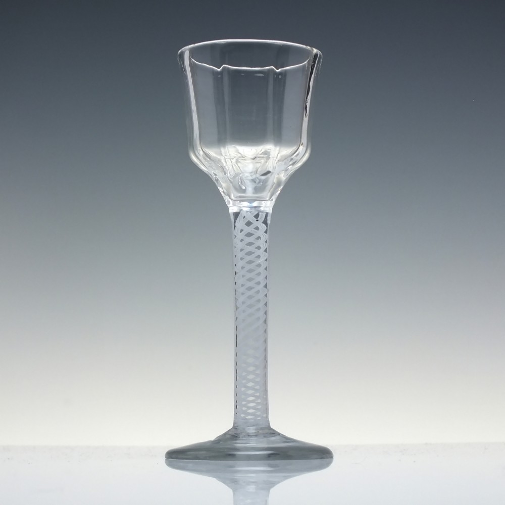 An 18th-century clear glass wine vessel featuring a ribbed ogee bowl supported by a stem with an internal white opaque twist motif resting on a conical foot. View II