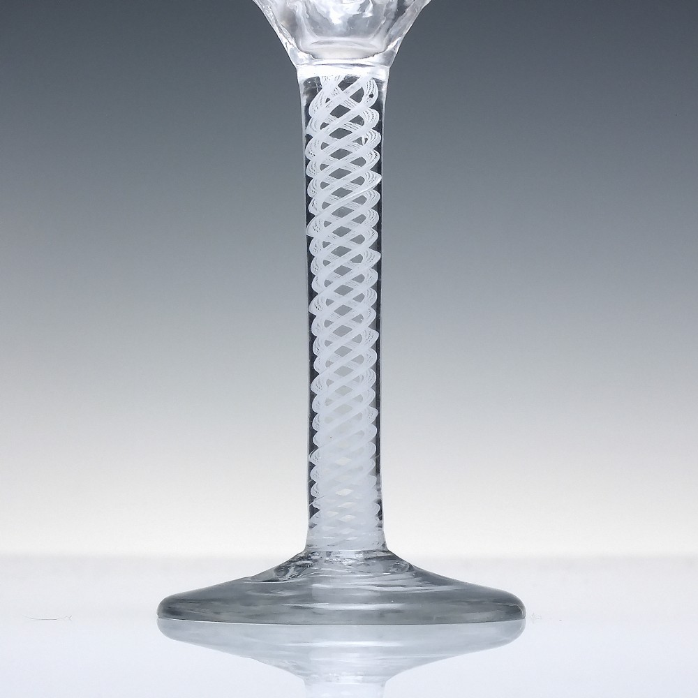 An 18th-century clear glass wine vessel featuring a ribbed ogee bowl supported by a stem with an internal white opaque twist motif resting on a conical foot. View III