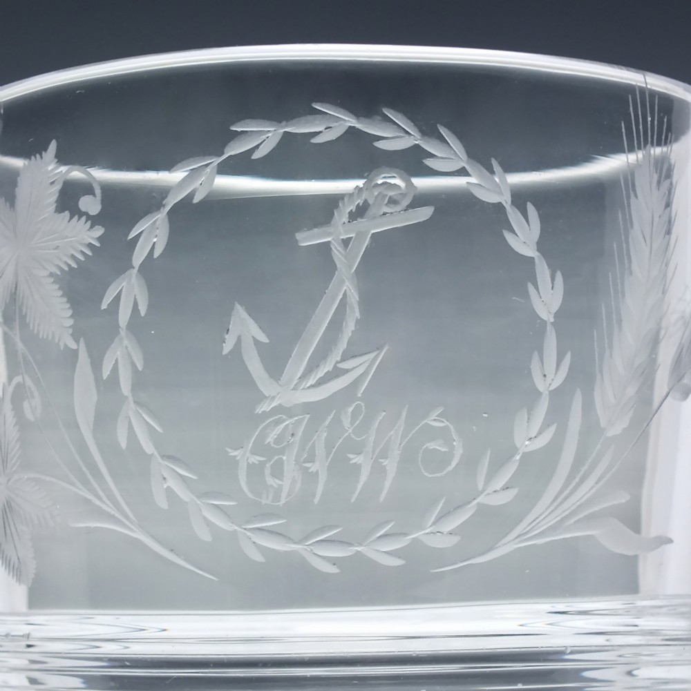 A clear Georgian lead crystal flip glass tumbler featuring lower cut panel flutes, a central waist ring, and upper wheel-engraved anchor and laurel wreath motifs. View II