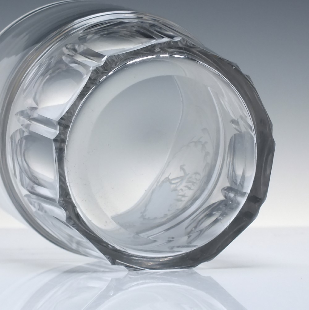 A clear Georgian lead crystal flip glass tumbler featuring lower cut panel flutes, a central waist ring, and upper wheel-engraved anchor and laurel wreath motifs. View VI