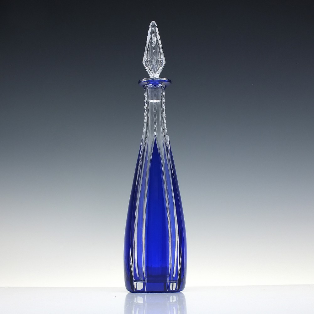 A tall, slender cobalt blue cut-to-clear crystal spirit decanter featuring vertical faceted flutes and a pointed, clear faceted stopper. View II