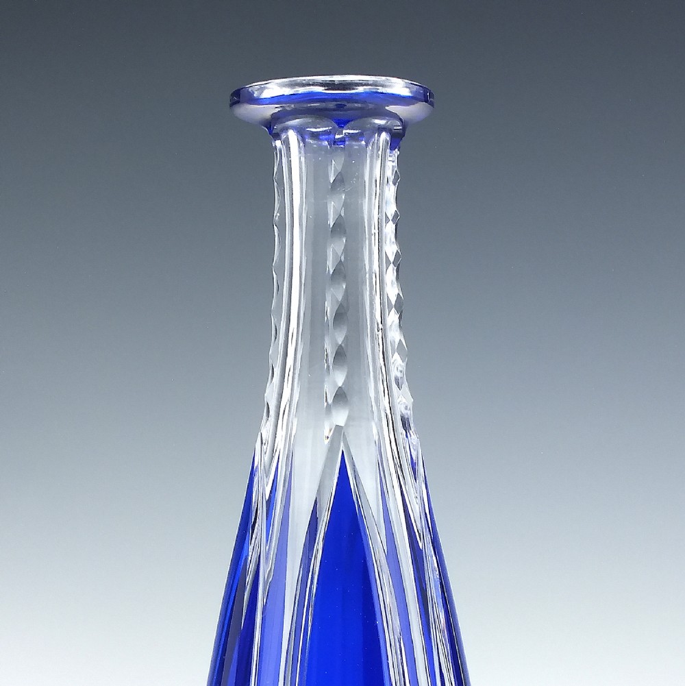 A tall, slender cobalt blue cut-to-clear crystal spirit decanter featuring vertical faceted flutes and a pointed, clear faceted stopper. View IV