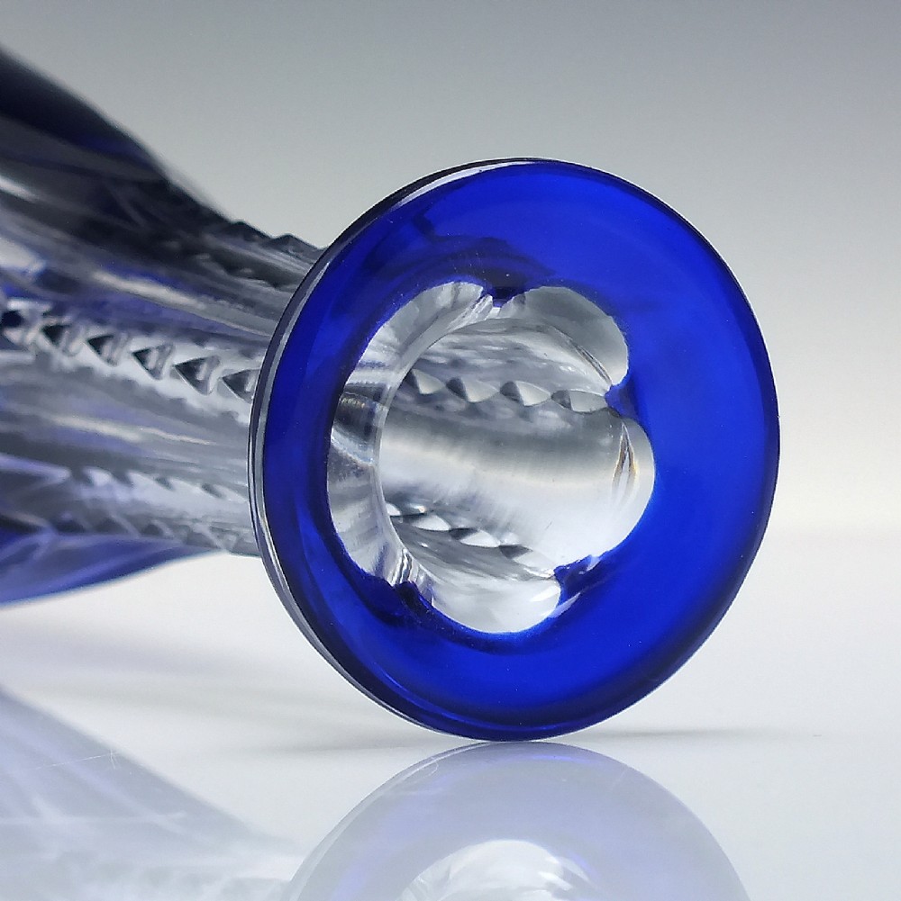 A tall, slender cobalt blue cut-to-clear crystal spirit decanter featuring vertical faceted flutes and a pointed, clear faceted stopper. View V