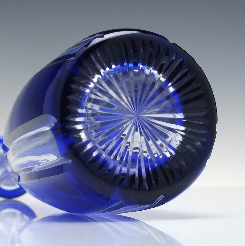 A tall, slender cobalt blue cut-to-clear crystal spirit decanter featuring vertical faceted flutes and a pointed, clear faceted stopper. View VI