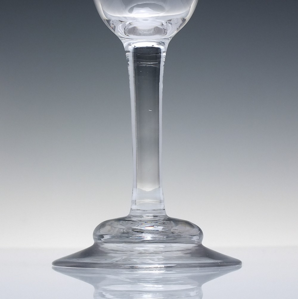 A clear 18th-century lead glass goblet featuring an engraved scroll border along the rim, a plain stem, and a circular foot. View III