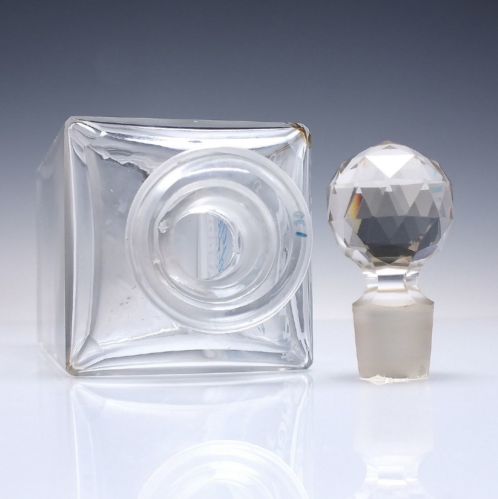 A rectangular clear glass whisky decanter featuring white and blue enamelled text reading Pigeon Blend Special and topped with a faceted glass stopper. View V