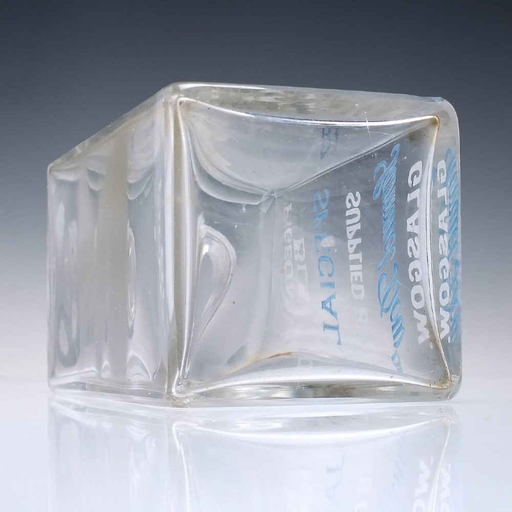 A rectangular clear glass whisky decanter featuring white and blue enamelled text reading Pigeon Blend Special and topped with a faceted glass stopper. View VI