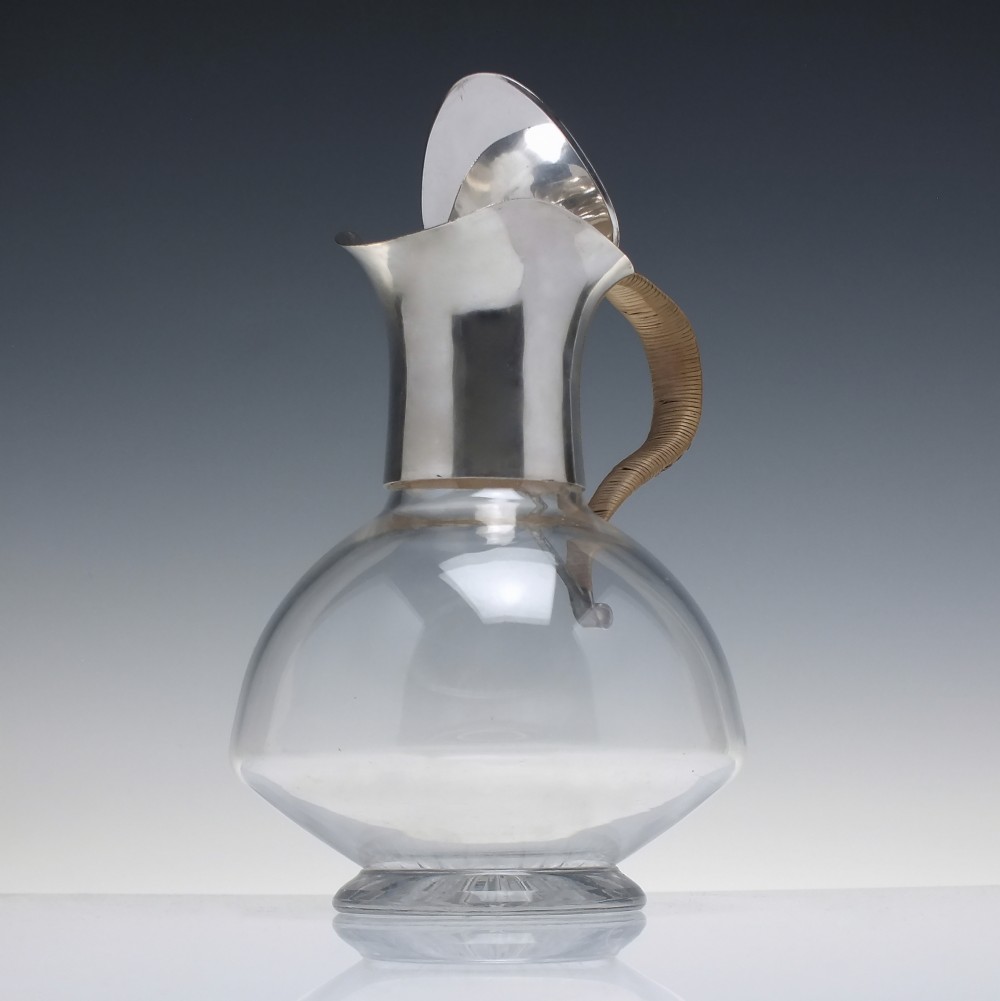 A late Victorian clear glass claret jug featuring a silver-plated neck, hinged lid, spout, and a cane-wrapped curved handle. View III