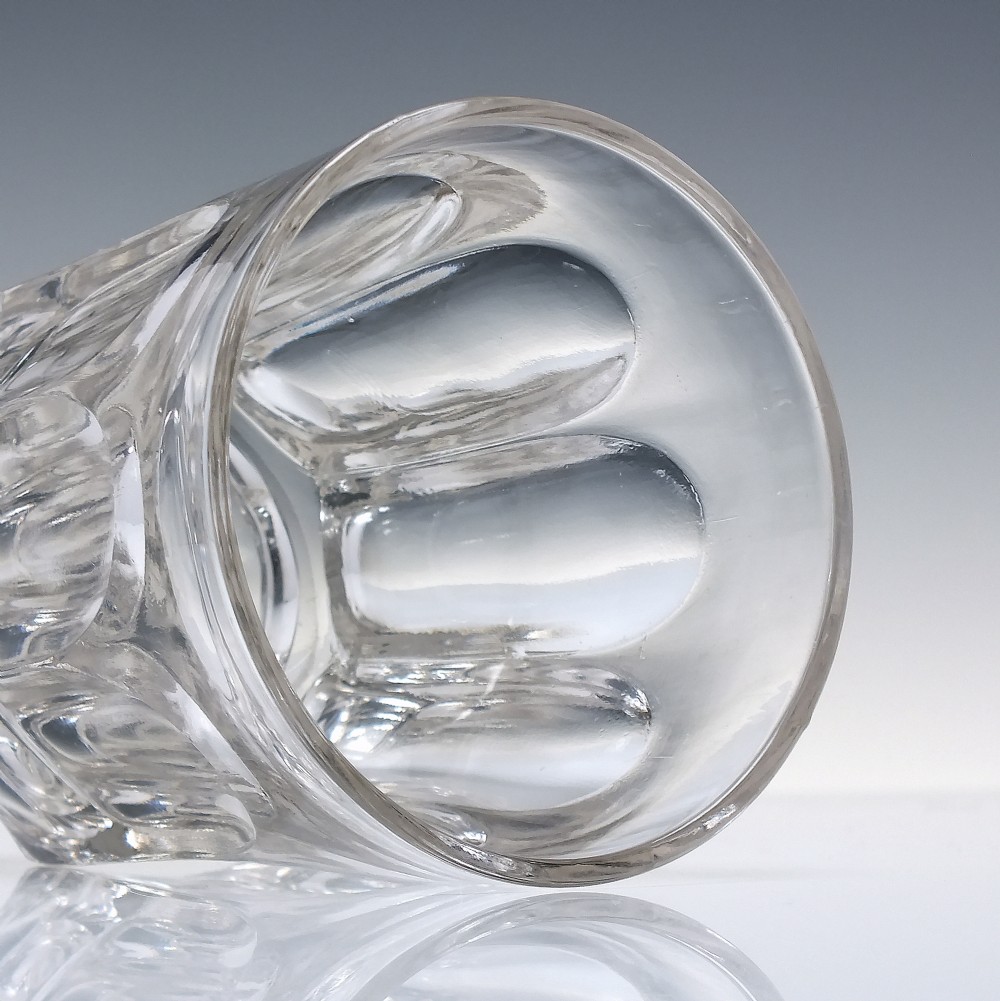 A clear Victorian glass whisky tumbler featuring fluted arch cuttings around the lower body and a thick base. View II