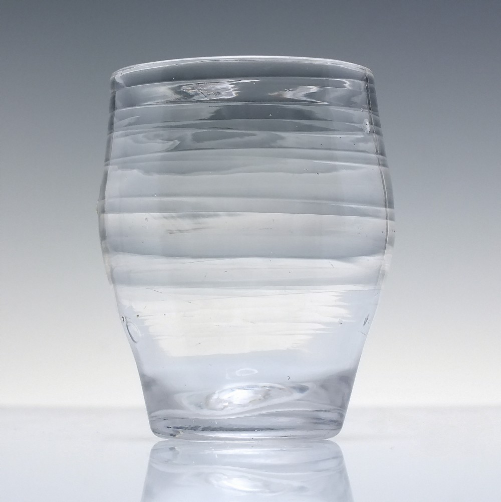 An 18th-century clear lead glass barrel-shaped dram tumbler featuring horizontal moulded rings around the exterior. View II