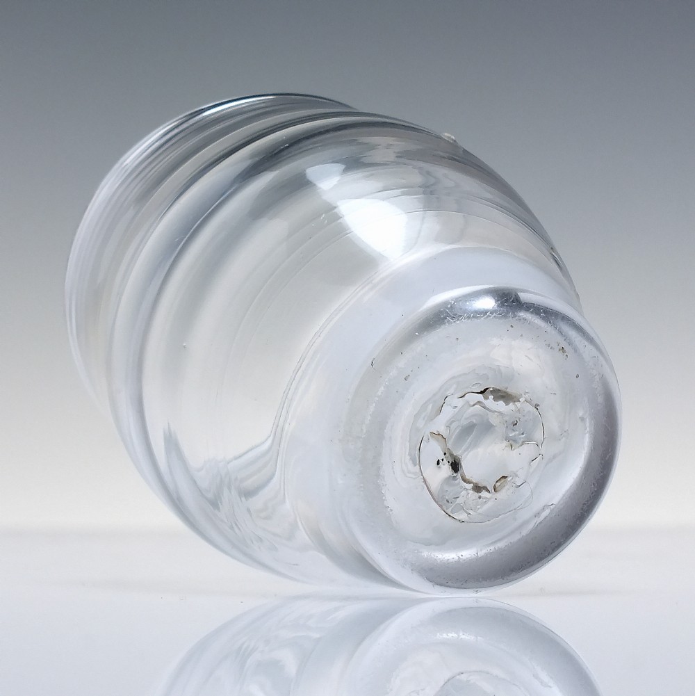 An 18th-century clear lead glass barrel-shaped dram tumbler featuring horizontal moulded rings around the exterior. View IV