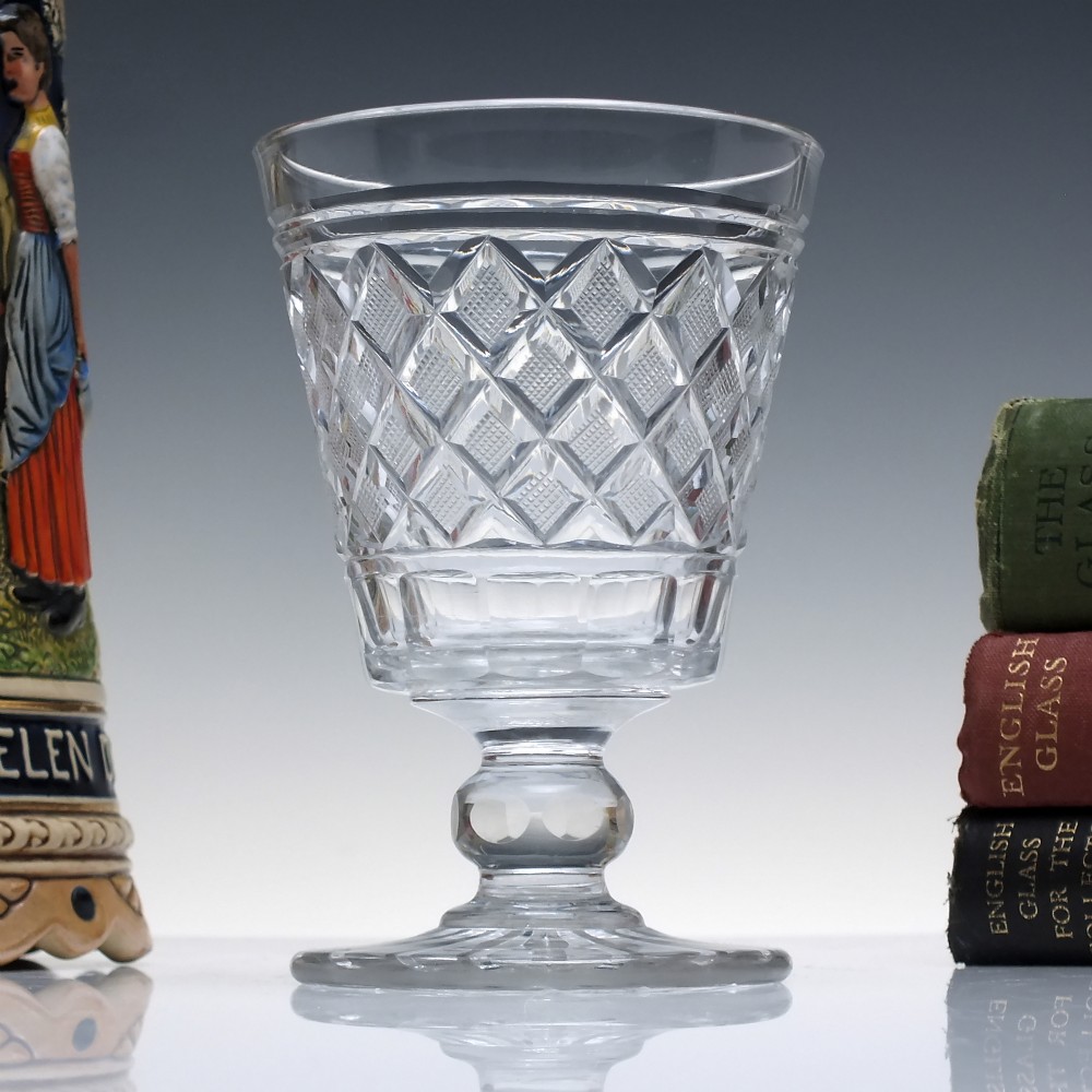 A clear Georgian cut lead crystal glass rummer featuring diamond-patterned facets and a knopped stem.