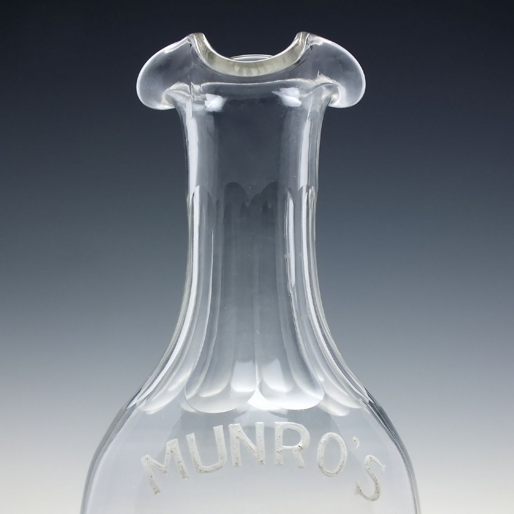 A clear glass antique whisky water carafe featuring white enamelled lettering for Dalwhinnie Scotch Whisky and a pinched pour spout. View VI