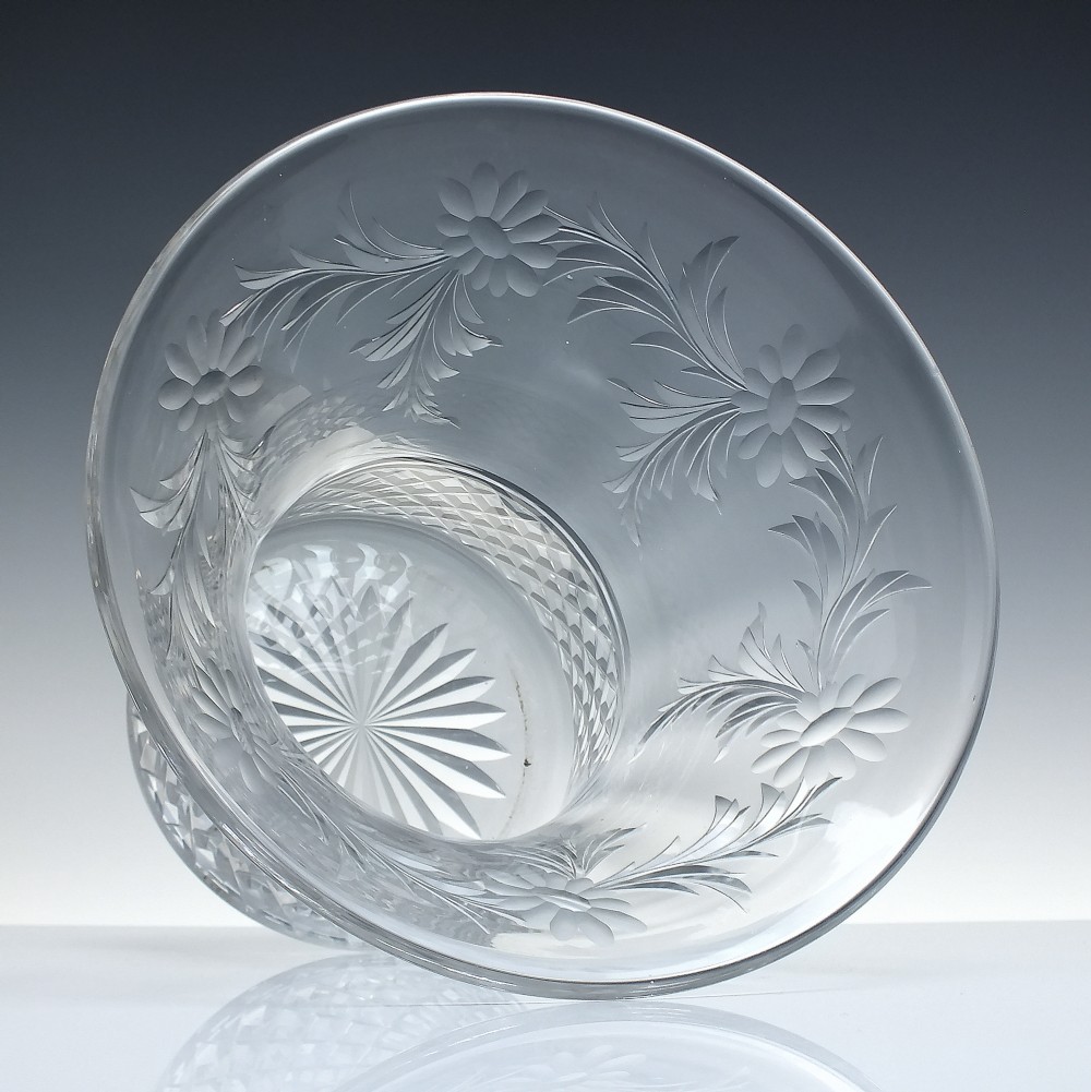 A clear cut crystal vase featuring a flared upper rim with engraved floral details above a geometric diamond-cut lower body. View II