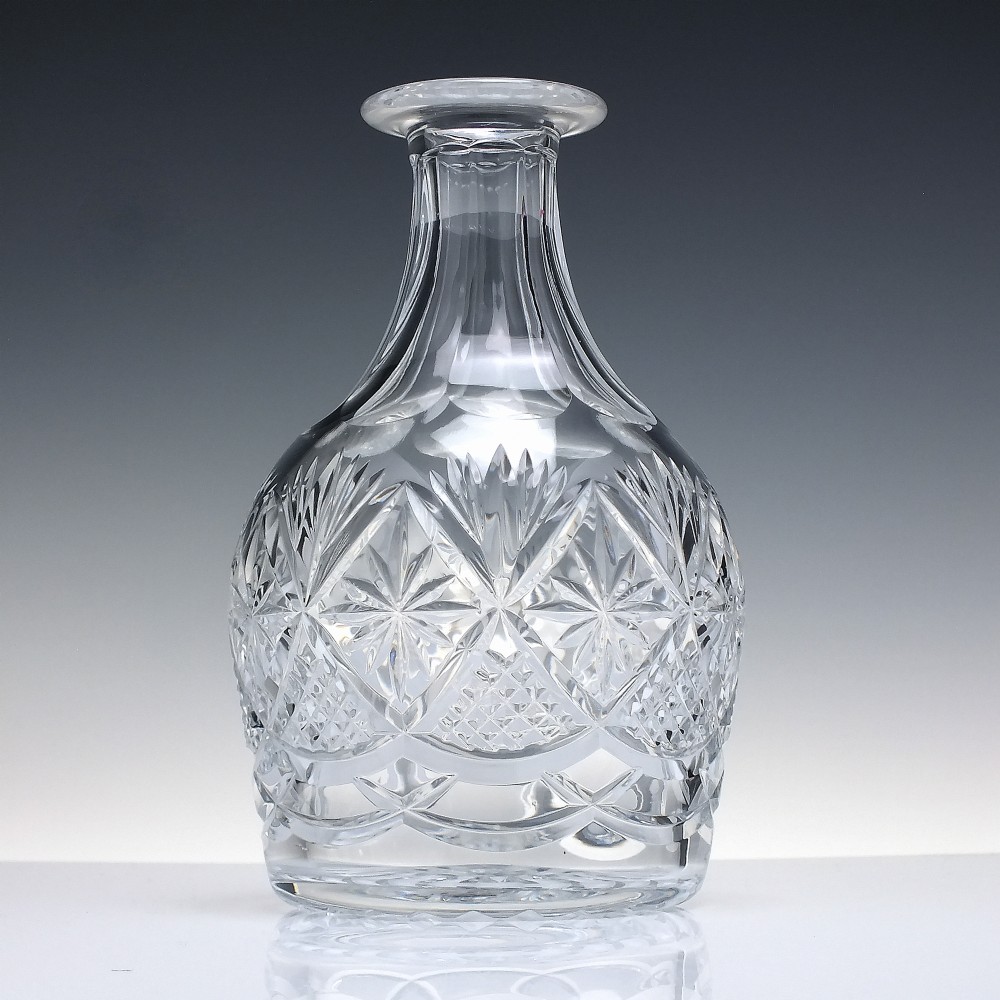 A clear cut lead crystal spirit decanter with starburst patterning and a fitted flat-topped glass stopper. View III
