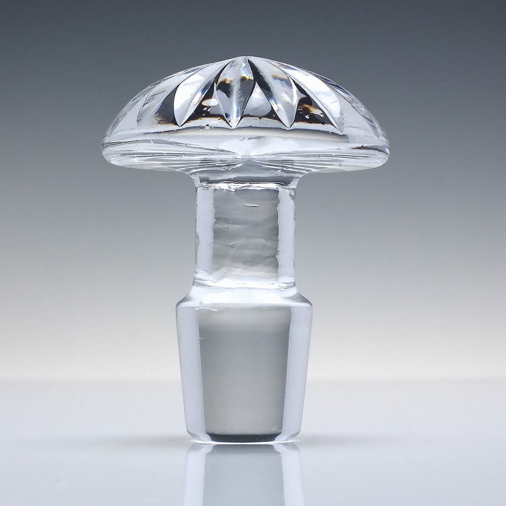 A clear cut lead crystal spirit decanter with starburst patterning and a fitted flat-topped glass stopper. View VII