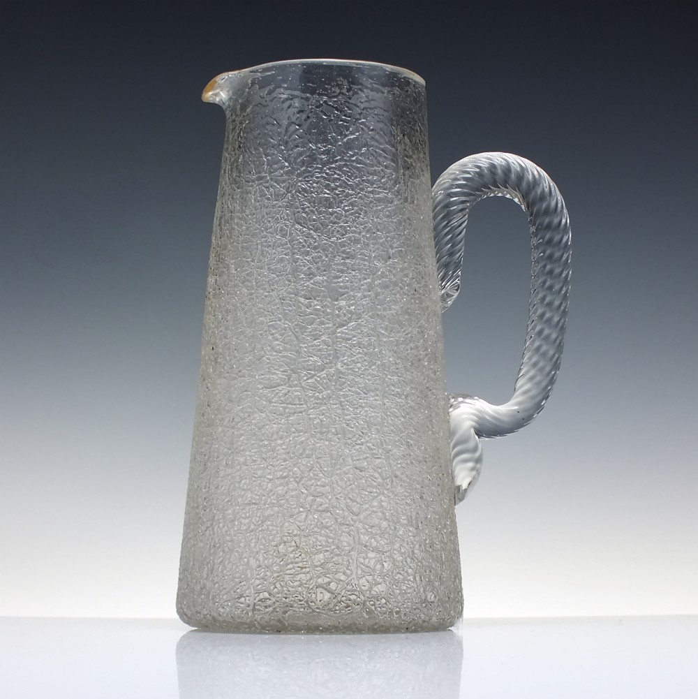 A late 19th-century clear overshot glass water jug featuring a textured ice-like body, a twisted applied glass handle, and a subtle gilded rim.