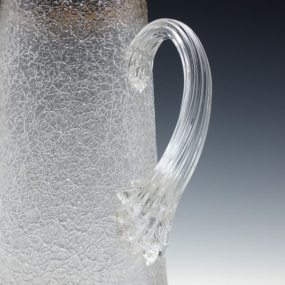 A tall nineteenth-century clear overshot glass water jug featuring a textured ice surface, an applied ribbed handle, and a gilded gold rim. View II