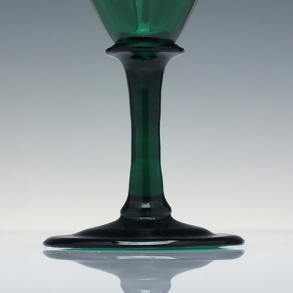 A mid-nineteenth-century wine glass made from deep emerald green glass with a slender stem and flat circular foot. View III