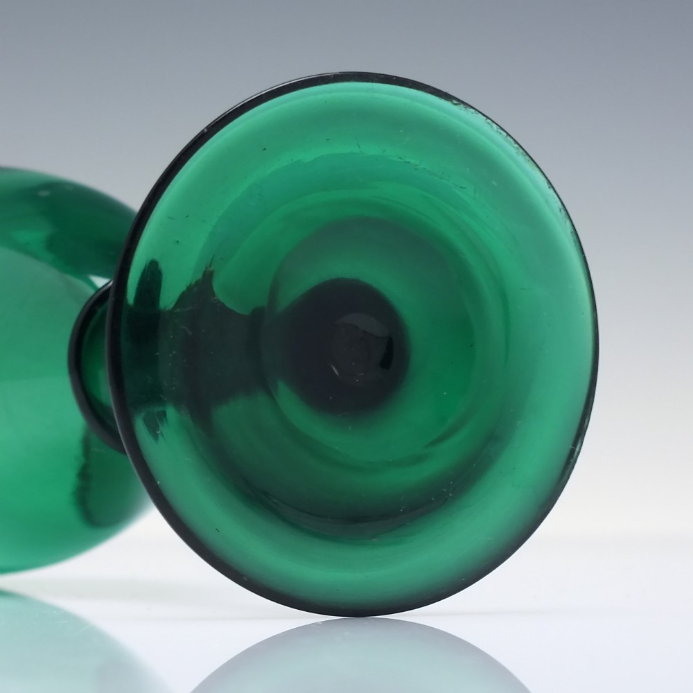 A mid-nineteenth-century wine glass made from deep emerald green glass with a slender stem and flat circular foot. View VI