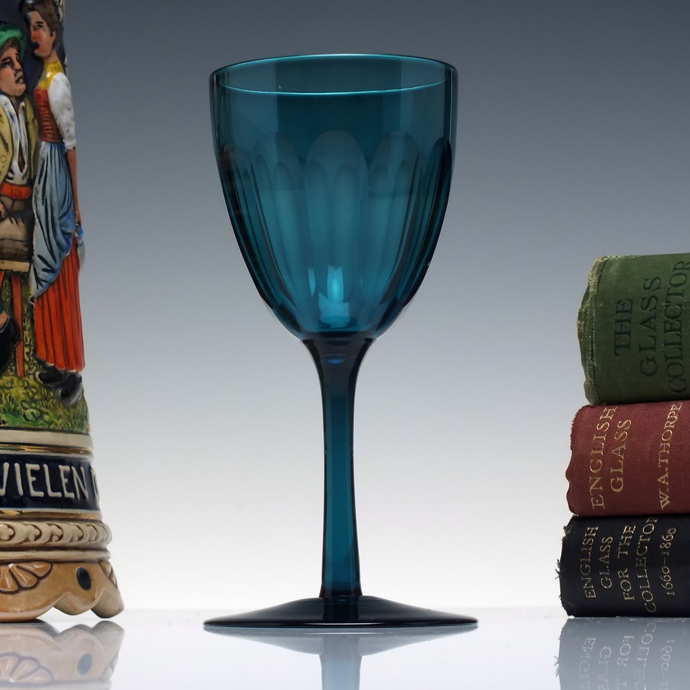 A Victorian peacock blue glass wine goblet featuring a panelled bowl, plain stem, and circular base.
