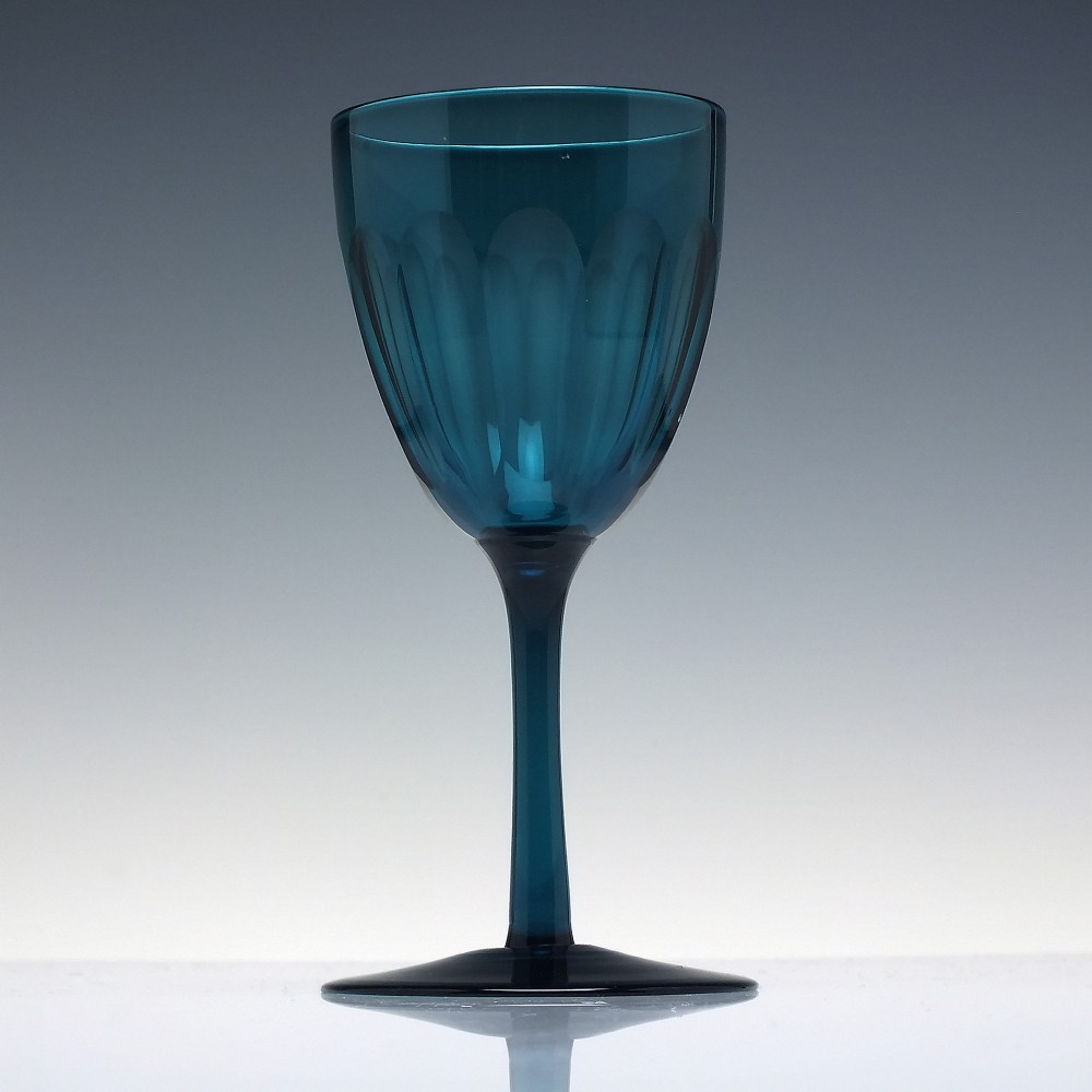 A Victorian peacock blue glass wine goblet featuring a panelled bowl, plain stem, and circular base. View II
