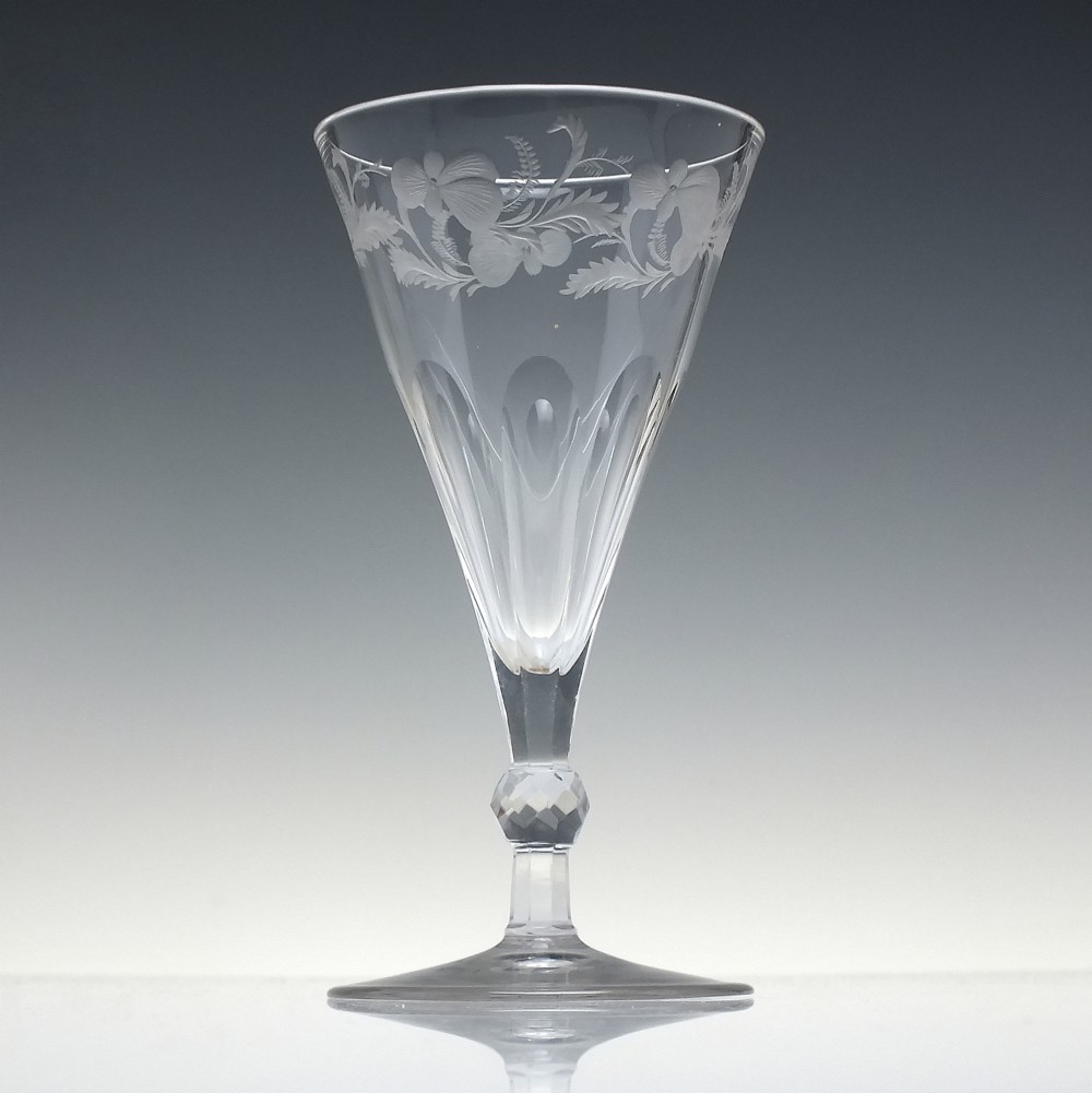 A clear 19th-century Victorian glass goblet with wheel-engraved floral motifs around the upper rim and facet cutting on the lower bowl and knopped stem. View II