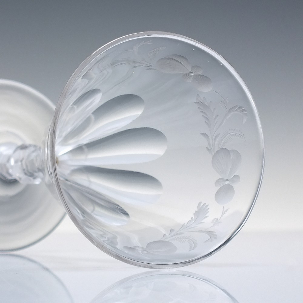 A clear 19th-century Victorian glass goblet with wheel-engraved floral motifs around the upper rim and facet cutting on the lower bowl and knopped stem. View V