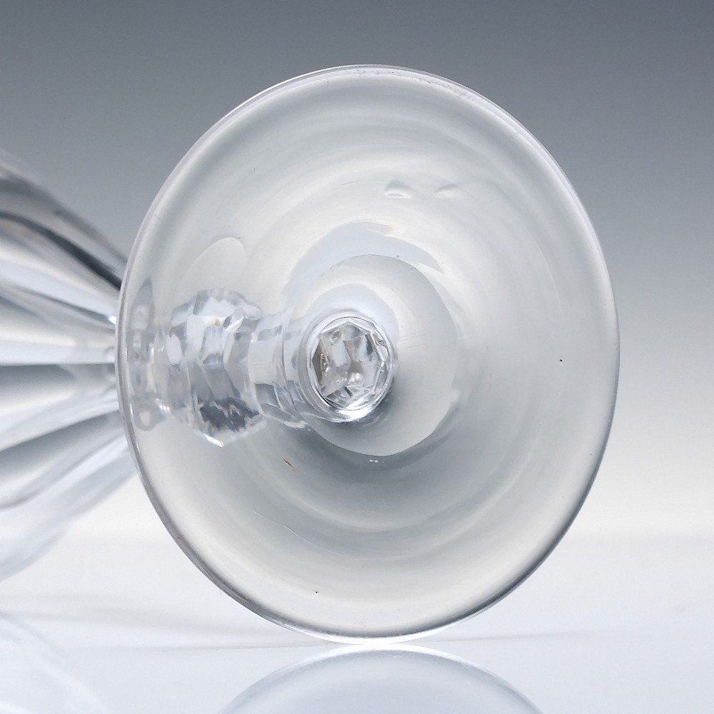 A clear 19th-century Victorian glass goblet with wheel-engraved floral motifs around the upper rim and facet cutting on the lower bowl and knopped stem. View VI