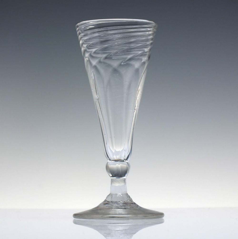 An eighteenth-century clear glass ale goblet featuring spiral wrythen moulding on a conical bowl supported by a knopped stem and circular foot. View II