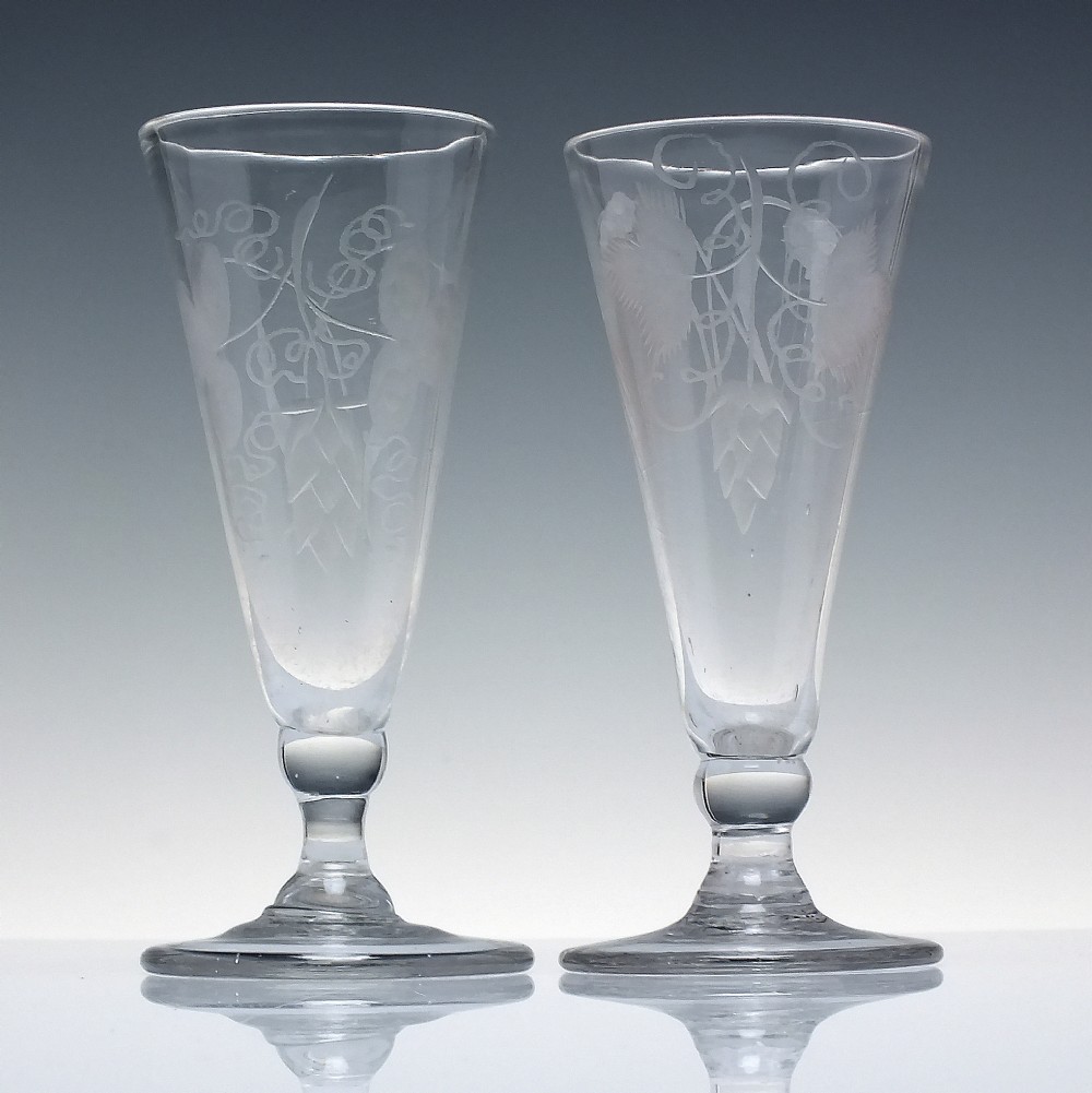 Pair of clear Georgian lead glass ale flutes featuring wheel-engraved barley and hops decoration on knopped stems. View II