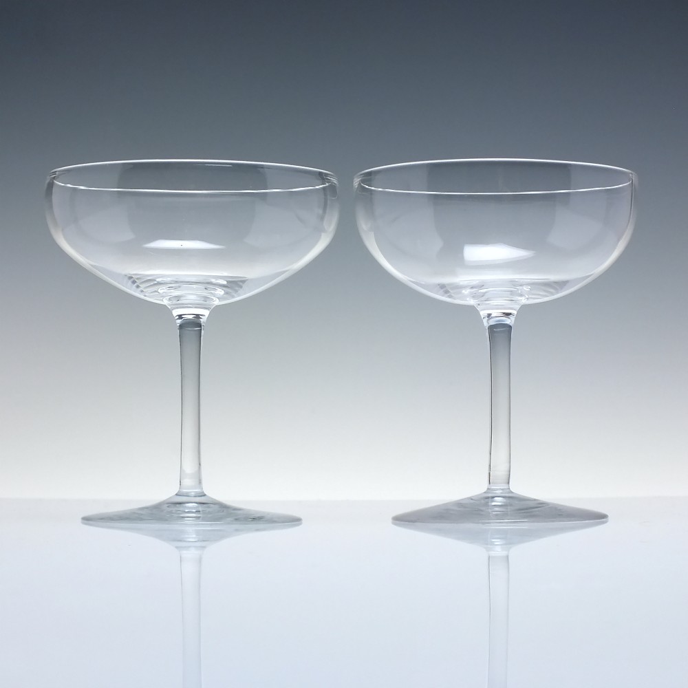 A set of six clear Edwardian crystal champagne coupes with wide saucer bowls and slender stems arranged in a line. View II