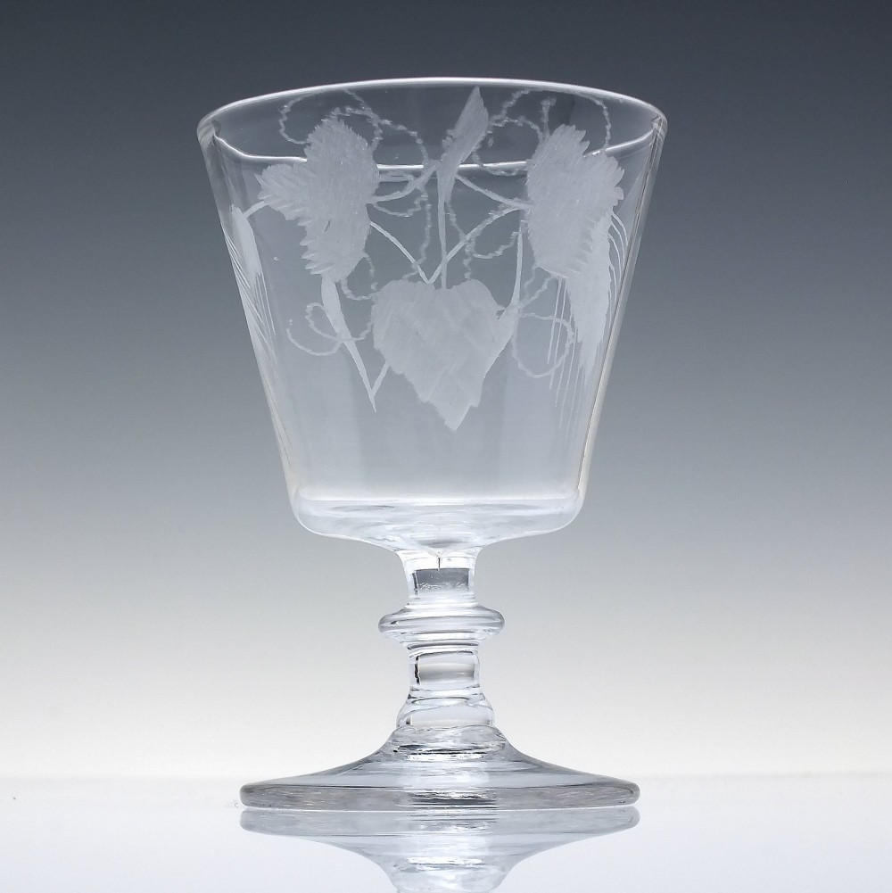 A clear Georgian glass rummer with a cup-shaped bowl wheel-engraved with hop and barley motifs, set on a short knopped stem and flat circular base. View II