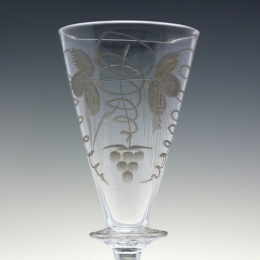A pair of clear hand-blown Georgian glass goblets featuring wheel-engraved motifs of hops and barley on conical bowls above knopped stems and conical bases. View V