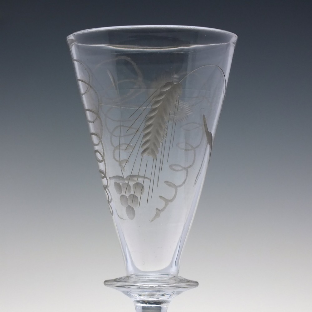 A pair of clear hand-blown Georgian glass goblets featuring wheel-engraved motifs of hops and barley on conical bowls above knopped stems and conical bases. View VII
