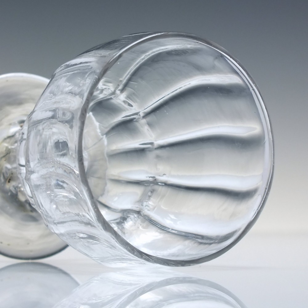 A small Georgian clear lead glass bonnet glass featuring a rib-moulded double-curved bowl, short pedestal stem, and flat circular foot. View III