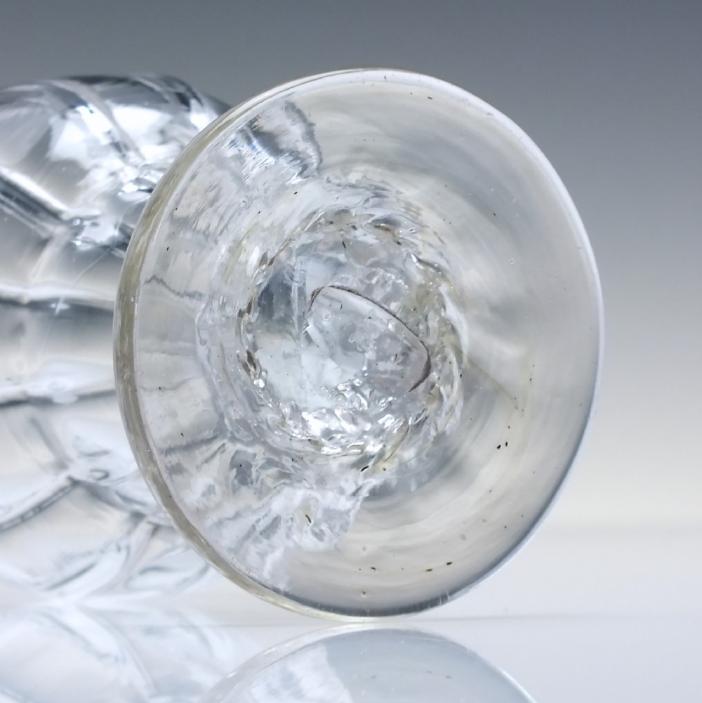 A small Georgian clear lead glass bonnet glass featuring a rib-moulded double-curved bowl, short pedestal stem, and flat circular foot. View IV