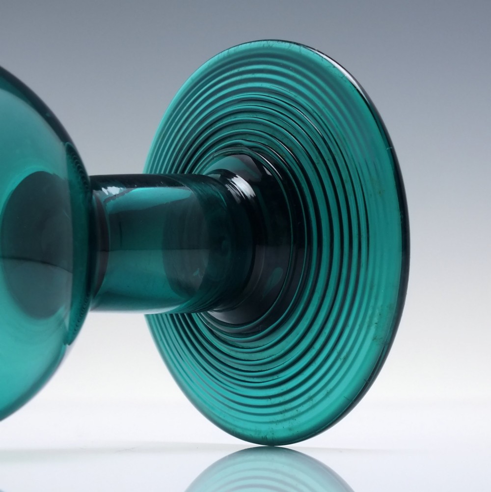 An 18th-century emerald green hand-blown glass wine goblet featuring a rounded cup, thick cylindrical stem, and circular foot. View IV